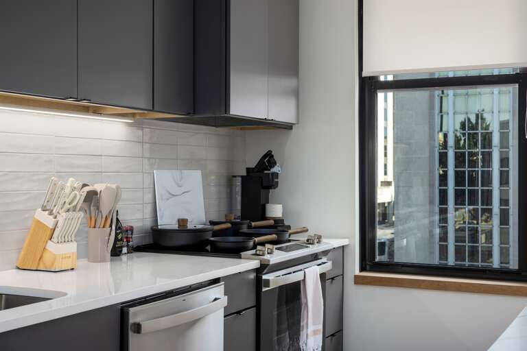 Fully stocked—this kitchen is ready for your culinary creations, with high-quality utensils, cookware, and a view of the city that adds inspiration to your meal prep.
