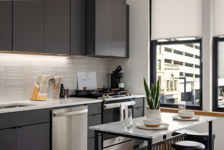 City living at its finest—prepare meals in this modern kitchen while enjoying views of Birmingham’s vibrant downtown through expansive windows.