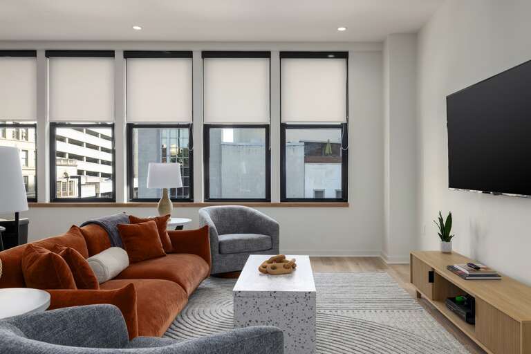 City views galore—this inviting living area, framed by large windows, lets in ample natural light, enhancing the modern aesthetic and creating a bright, welcoming space.