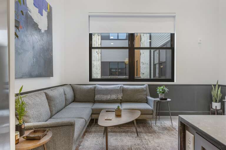 This photo emphasizes the beautiful contemporary artwork above the sofa, adding depth and intrigue to the living area, making it a focal point of the room. This photo emphasizes the beautiful contemporary artwork above the sofa, adding depth and intrigue to the living area, making it a focal point of the room.