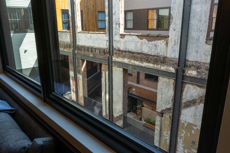 This view from the living area’s window offers a glimpse into the urban environment surrounding the property, featuring the architectural details of the neighboring buildings. This view from the living area’s window offers a glimpse into the urban environment surrounding the property, featuring the architectural details of the neighboring buildings.