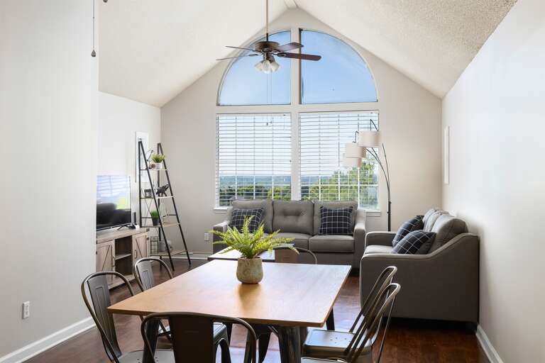 Living room with vaulted ceilings, large windows, and tasteful decor Living room with vaulted ceilings, large windows, and tasteful decor