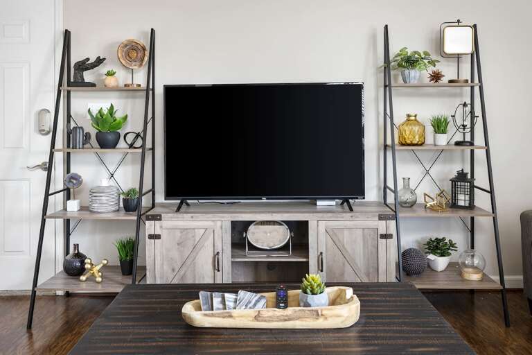 Entertainment area featuring a large flat-screen TV surrounded by chic shelving and decor accents. Entertainment area featuring a large flat-screen TV surrounded by chic shelving and decor accents.
