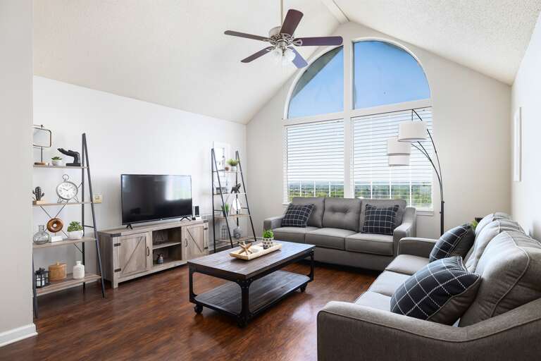 Stylish living area with ample seating, a modern TV setup, and natural light Stylish living area with ample seating, a modern TV setup, and natural light