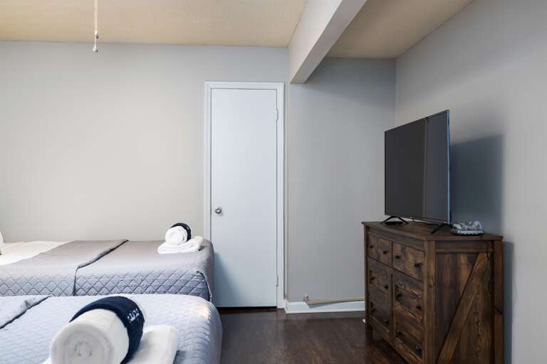 Relaxing bedroom with two queen beds, smart TV, and minimalist decor Relaxing bedroom with two queen beds, smart TV, and minimalist decor