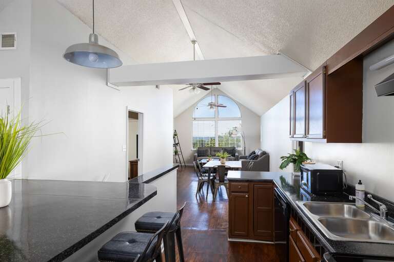Open-concept dining and kitchen area with vaulted ceilings and contemporary decor. Open-concept dining and kitchen area with vaulted ceilings and contemporary decor.