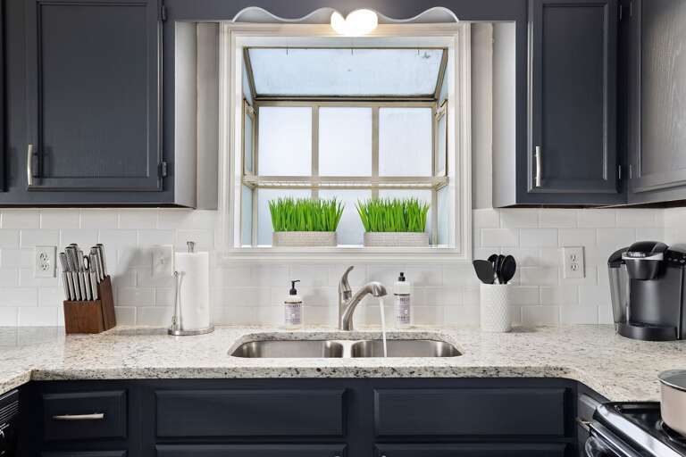 Bright kitchen sink area with granite countertops, stainless fixtures, and modern cabinets. Bright kitchen sink area with granite countertops, stainless fixtures, and modern cabinets.