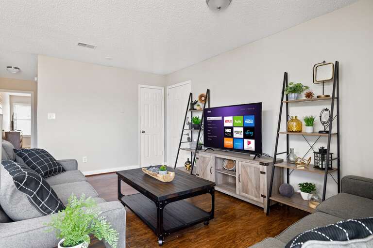  Living room entertainment setup with a smart TV, modern shelving, and stylish decor.