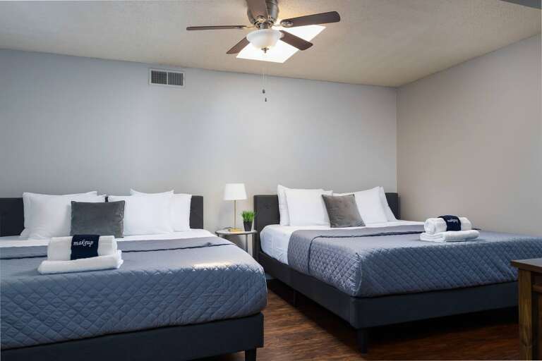Bedroom with two king-size beds and neutral tones for a relaxing, spacious retreat.