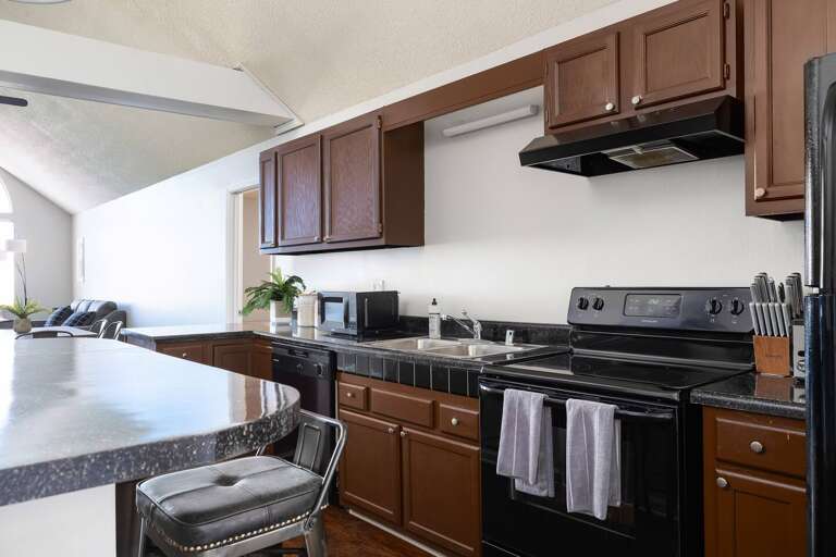 Fully equipped kitchen with sleek countertops, a stovetop, and plenty of workspace.