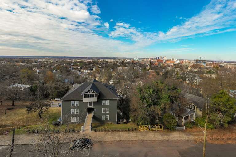 Wide aerial shot showing the property’s location with city views in the distance.