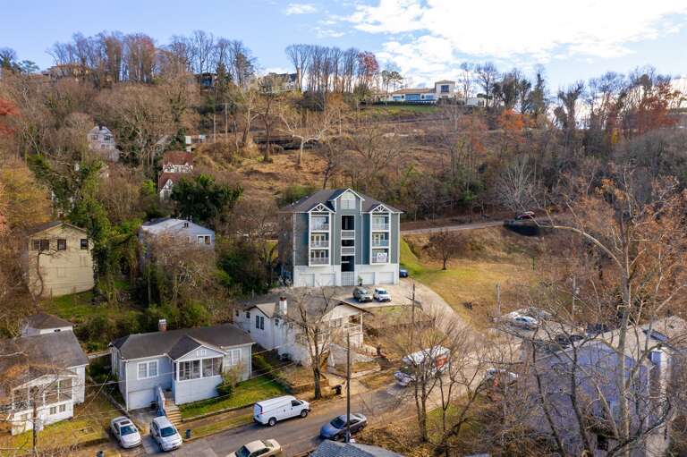Aerial view of the property nestled in a quiet neighborhood with greenery and charm.