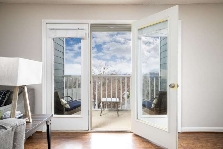 Bright and airy view from the living room leading to a balcony with stunning outdoor scenery. Bright and airy view from the living room leading to a balcony with stunning outdoor scenery.