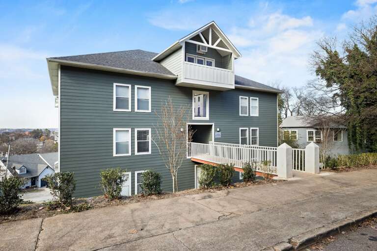 Exterior of Hilltop Hideaway, a stylish multi-unit building with a modern green facade and a welcoming entrance. Exterior of Hilltop Hideaway, a stylish multi-unit building with a modern green facade and a welcoming entrance.