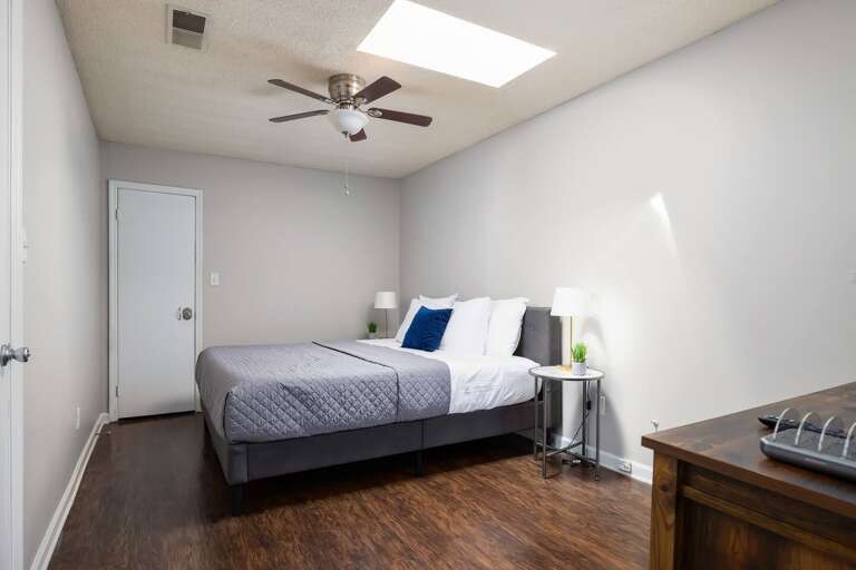 Bedroom 2 with a king-size bed, skylight, and modern decor for a bright and cozy feel.