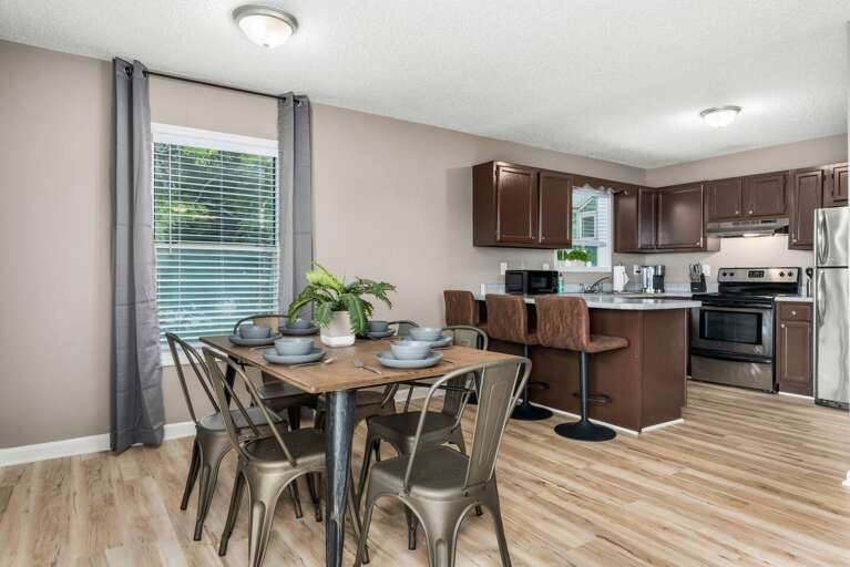 Dining area with a round table, modern chairs, and ample natural light for cozy meals.