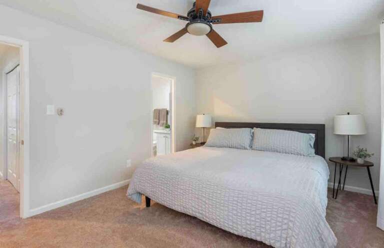 Primary bedroom with a king-size bed, ceiling fan, and a serene design for ultimate relaxation. Primary bedroom with a king-size bed, ceiling fan, and a serene design for ultimate relaxation.