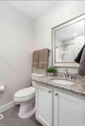 Bathroom with a granite countertop, fresh greenery, and ample space for your essentials. Bathroom with a granite countertop, fresh greenery, and ample space for your essentials.