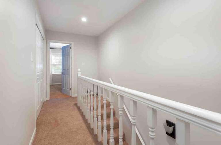 Bright hallway with soft carpeting and a clean, open design leading to the upper level. Bright hallway with soft carpeting and a clean, open design leading to the upper level.