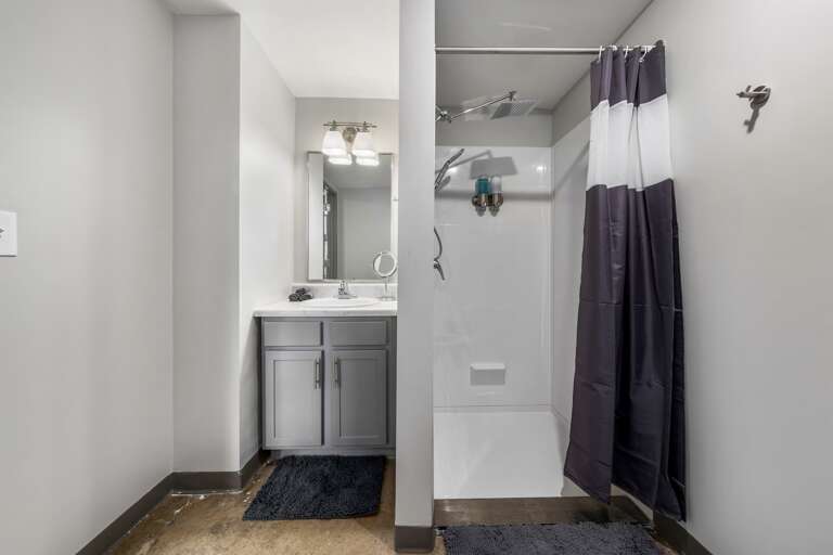 Functional bathroom with a spacious shower, fresh towels, and sleek finishes.
