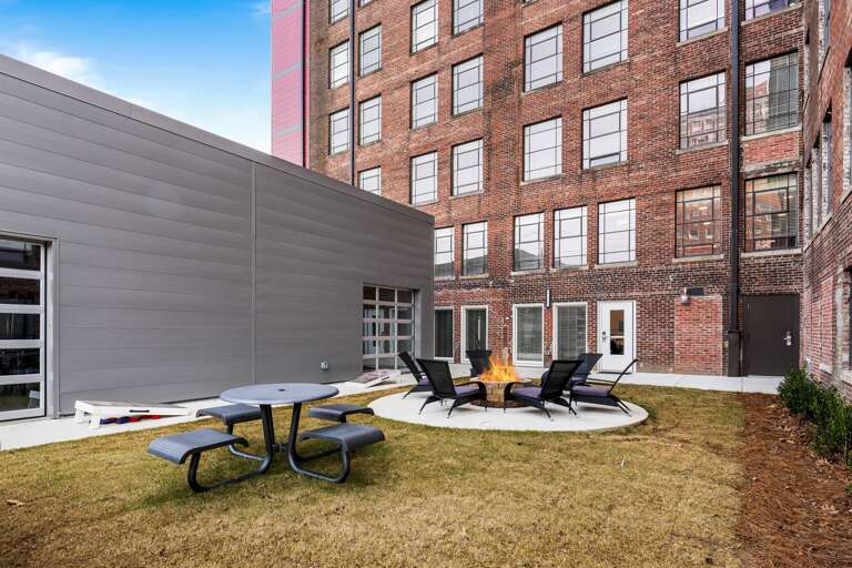 Open common courtyard area featuring a mix of seating and greenery, perfect for social gatherings.