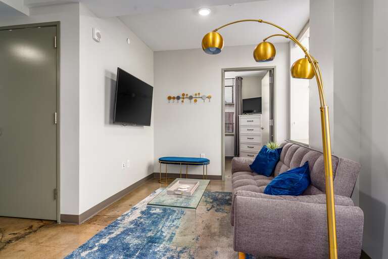 Stylish seating area with a unique floor lamp and plush armchairs for relaxation.