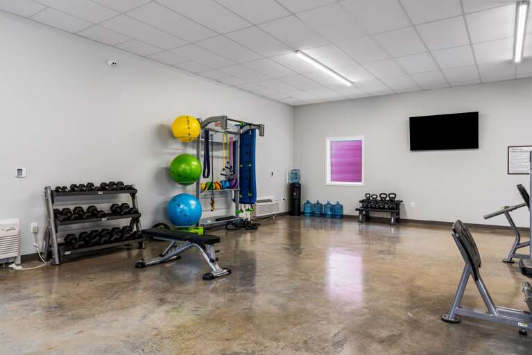 Fully equipped fitness center featuring a range of exercise machines and weights.