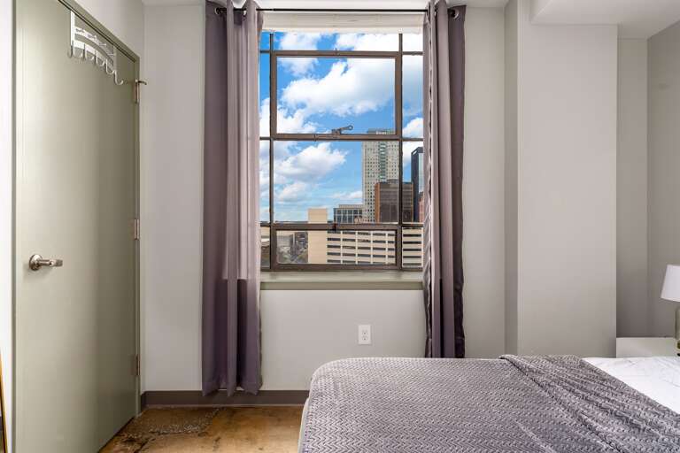 Bedroom window offering stunning views of the city skyline and natural light.