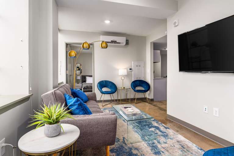 Cozy living room with vibrant accents, a flat-screen TV, and comfortable seating.