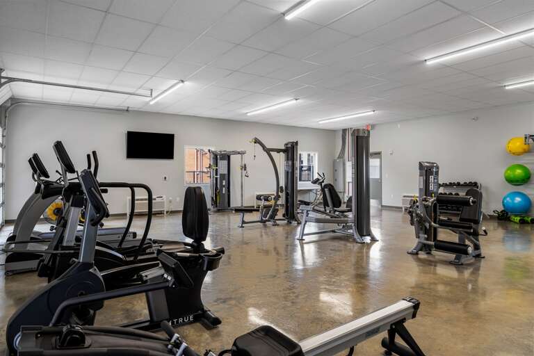 Fully equipped fitness center with a variety of cardio machines and free weights.