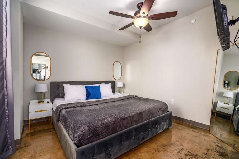 Spacious bedroom with luxurious bedding, modern decor, and a serene ambiance.