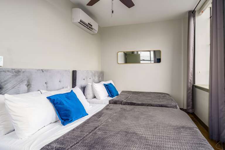 Double queen bedroom retreat with luxurious bedding, natural light, and soothing tones.