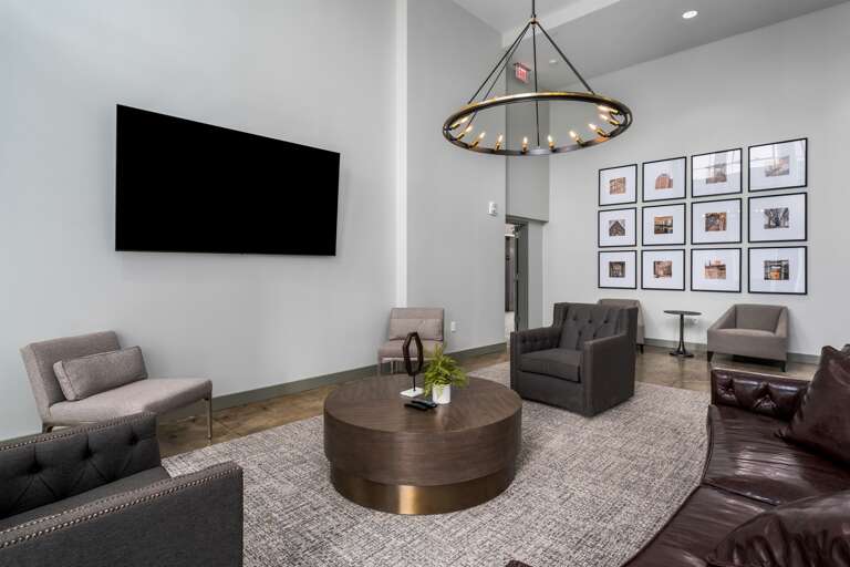 Elegant common lounge featuring a modern chandelier, comfortable seating, and vibrant decor.