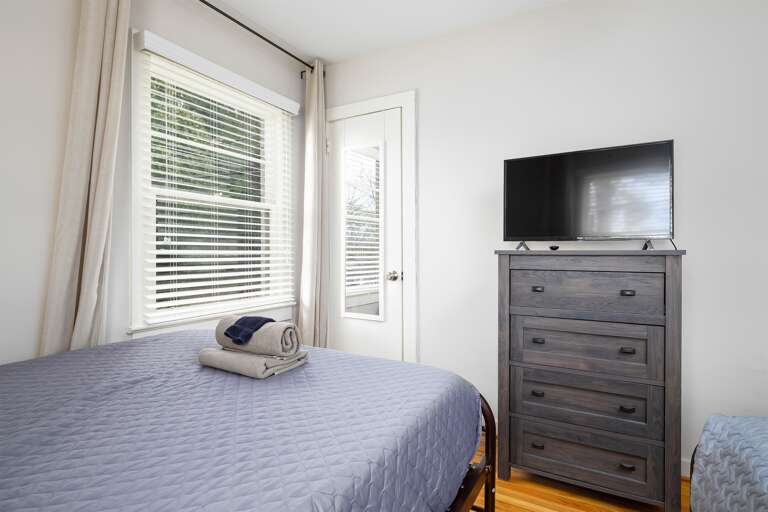 A different angle of the double-queen bedroom showcasing the dresser and smart TV, perfect for unwinding after a day out.