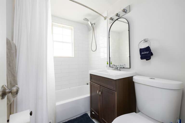 Modern bathroom with a tub/shower combo, a sleek vanity, and fresh linens provided for your convenience.
