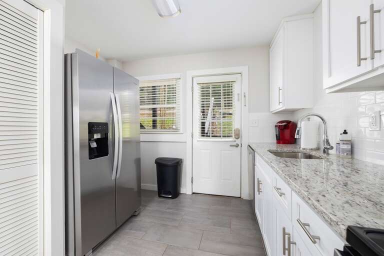 A back door provides easy access to the outdoor seating area and parking. The kitchen includes a Keurig coffee maker for your morning brews.