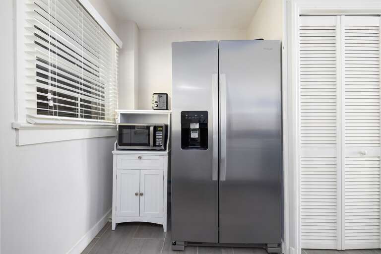 A closer look at the kitchen’s side-by-side refrigerator and built-in microwave, providing both functionality and style.