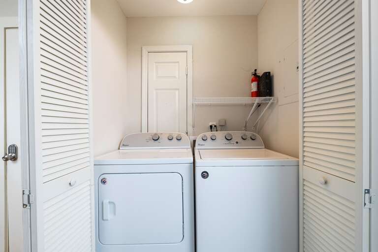 In-unit washer and dryer tucked neatly into a closet, providing the convenience of doing laundry during your stay.