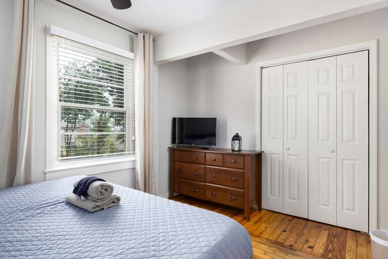 Master bedroom with a wide dresser, TV, and closet space to make your stay as comfortable as possible.