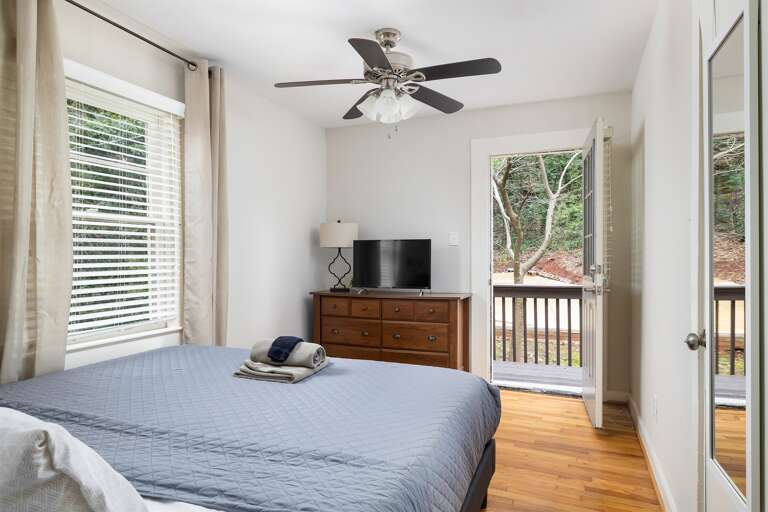 Spacious master bedroom featuring a plush king bed with fresh linens, bedside lighting, and a warm, inviting atmosphere.