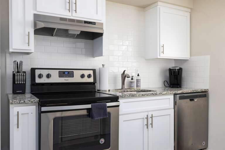 A closer look at the modern stove, dishwasher, and countertop space, making meal prep a breeze.