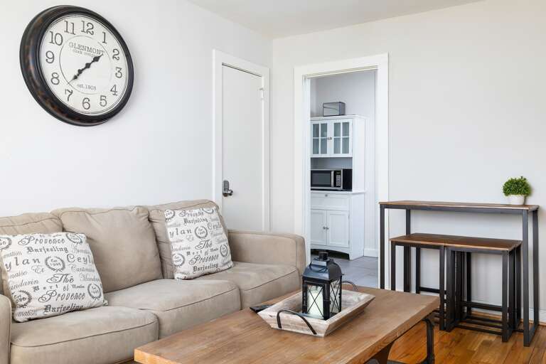 Unit B’s living room is warm and inviting, with comfortable seating, a farmhouse clock, and plenty of natural light. Unit B’s living room is warm and inviting, with comfortable seating, a farmhouse clock, and plenty of natural light.