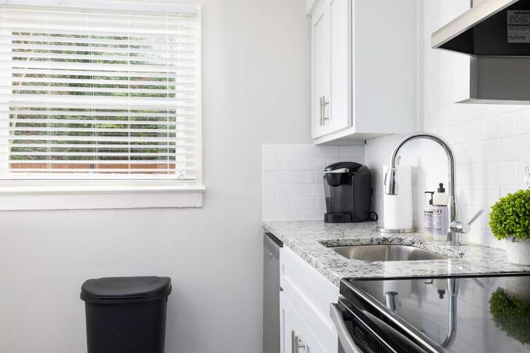 A sleek and modern kitchen with white cabinets, stainless steel appliances, and a stylish backsplash. Fully equipped for preparing your favorite meals. A sleek and modern kitchen with white cabinets, stainless steel appliances, and a stylish backsplash. Fully equipped for preparing your favorite meals.