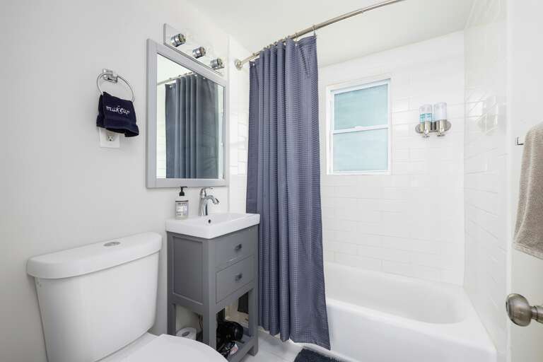 Modern bathroom with a combination tub and shower, a sleek vanity, and plush towels for your convenience. Modern bathroom with a combination tub and shower, a sleek vanity, and plush towels for your convenience.