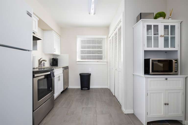 Unit D’s kitchen is fully equipped with stainless steel appliances, white cabinets, and a sleek, functional design. Unit D’s kitchen is fully equipped with stainless steel appliances, white cabinets, and a sleek, functional design.