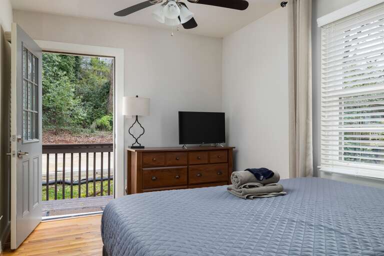 Alternate view of the master bedroom, featuring a dresser, TV, and direct access to the private outdoor seating area. Alternate view of the master bedroom, featuring a dresser, TV, and direct access to the private outdoor seating area.