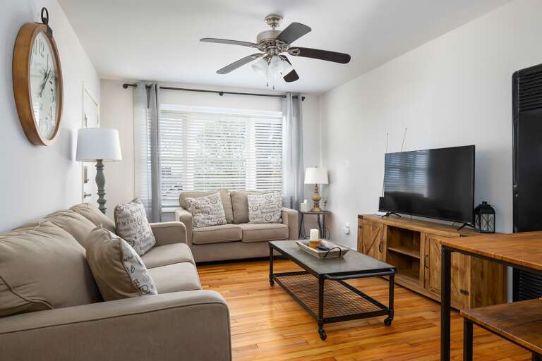 Unit B's living room mirrors the inviting design of Unit A, with soft beige couches, a smart TV, and a warm, welcoming atmosphere. Unit B's living room mirrors the inviting design of Unit A, with soft beige couches, a smart TV, and a warm, welcoming atmosphere.