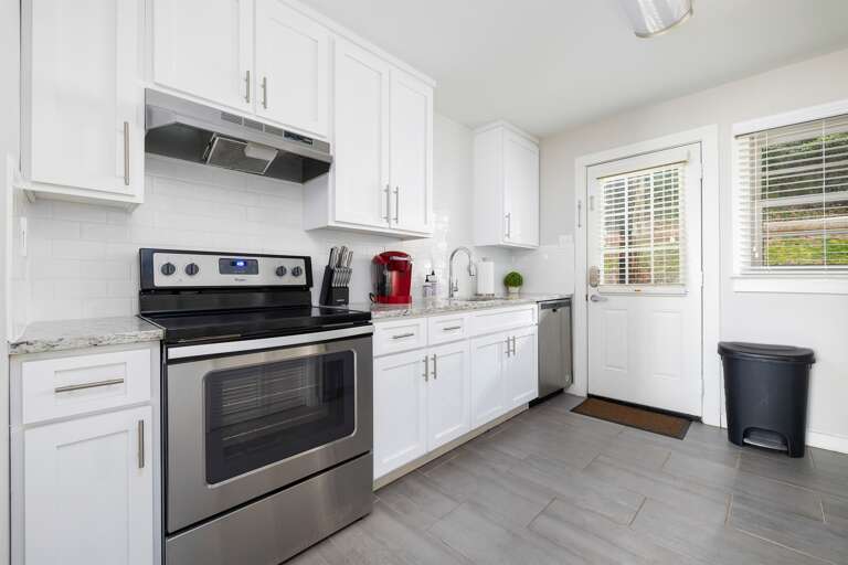 Bright and spacious kitchen featuring modern stainless steel appliances, white cabinets, and granite countertops. Fully equipped for all your cooking needs. Bright and spacious kitchen featuring modern stainless steel appliances, white cabinets, and granite countertops. Fully equipped for all your cooking needs.