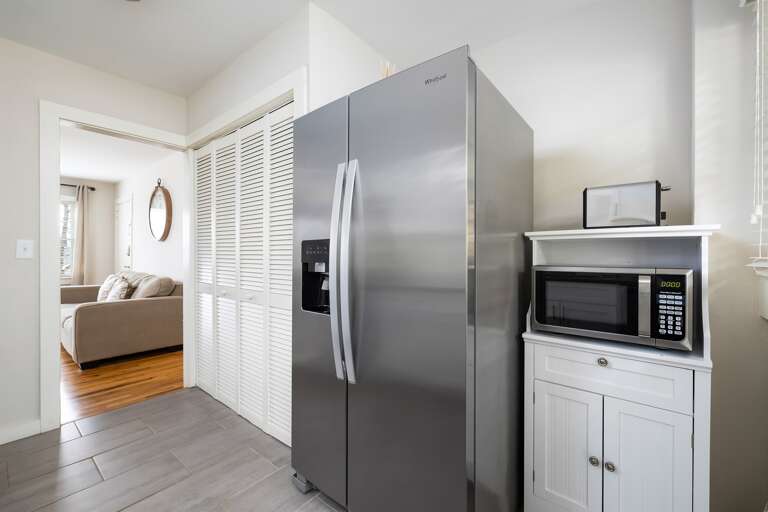 Spacious kitchen with a side-by-side refrigerator, built-in microwave, and plenty of counter space for cooking and dining. Spacious kitchen with a side-by-side refrigerator, built-in microwave, and plenty of counter space for cooking and dining.