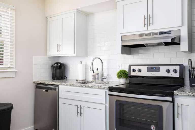 Fully equipped kitchen with stainless steel appliances, white cabinetry, and ample counter space for preparing meals during your stay. Fully equipped kitchen with stainless steel appliances, white cabinetry, and ample counter space for preparing meals during your stay.